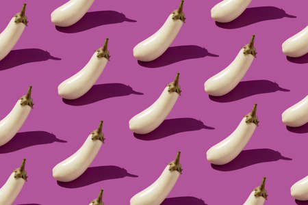 White aubergine eggplant pattern on purple background. Minimal vegetable concept.の写真素材