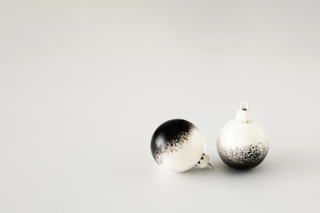 Minimal Christmas composition. Black and white baubles on white background. Christmas, winter, new year concept. Front view, copy space.の写真素材