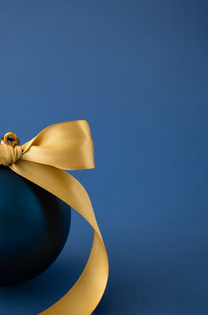 Blue Christmas bauble decoration with yellow ribbon. Minimal New Year concept.の写真素材
