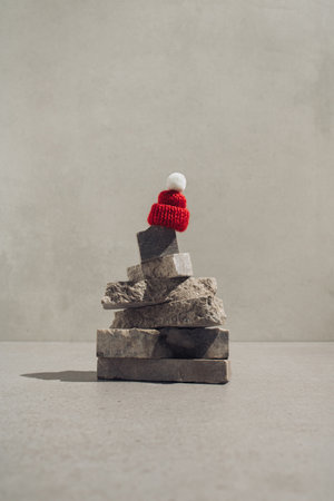 Red winter hat on top of natural stone Christmas tree.  Minimal greeting concept.の写真素材