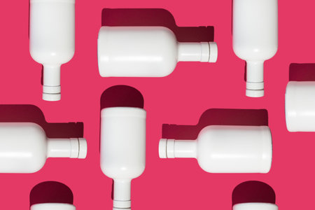 Trendy beverage closeup pattern made with white bottle on magenta background. Minimal vibrant concept.の写真素材