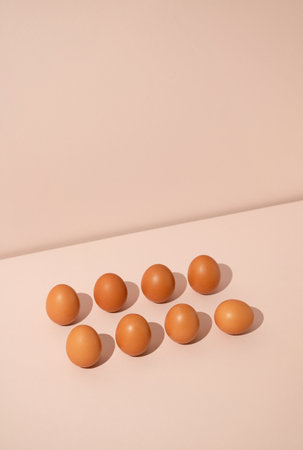 Eight fresh brown eggs on pastel background. Minimal food concept.の写真素材