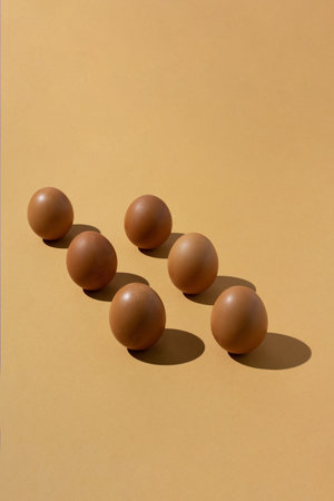 Six fresh chicken eggs on beige background. Minimal concept.の写真素材