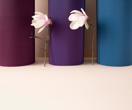 Three corrugated cardoard columns with two fresh magnolia branches with flowers in between. Minimal spring concept.の写真素材