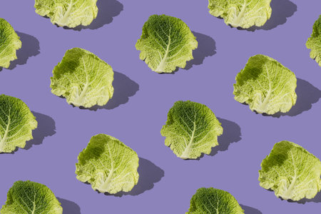 Pattern with fresh kale leafs against purple background. Minimal food vegetable concept.の写真素材