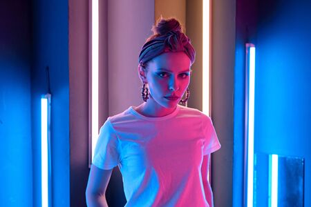 Portrait of a beautiful girl with colored lighting. Red and blue lights.