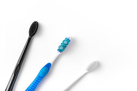 A set of multi-colored toothbrushes on a white background. Place to write the text.