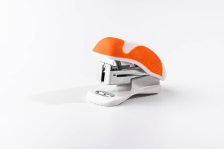 A small orange stapler isolated on a white background. Close-up. Copy space. Space for textの写真素材