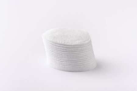 Cotton disks are stacked on a white backgroundの写真素材