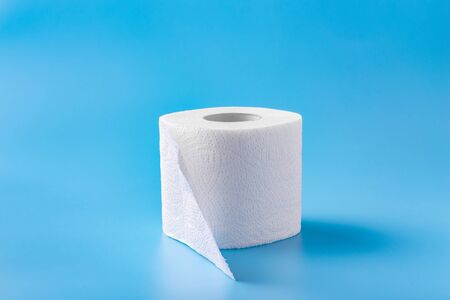A roll of toilet paper on a blue background. Copy space. Space for text.の写真素材