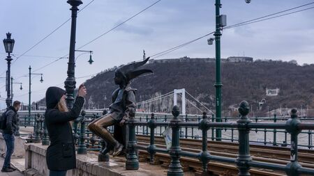Budapest, Hungary 03 15 2019 the Little Princess (KiskirÃ¡lylÃ¡ny) statue sitting on the railings of the Danube promenade in Budapest, Hungary was created by LÃ¡szlÃ³ Martonのeditorial素材