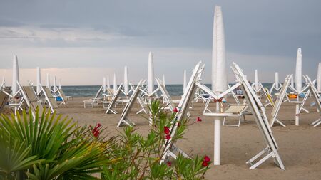 sunbeds and parasols collapsed due to the upcoming stormの写真素材