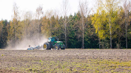 Nagybajcs Hungary 04 04 2020: A large, modern John Deere 4755 tractor with double wheels goes in the...