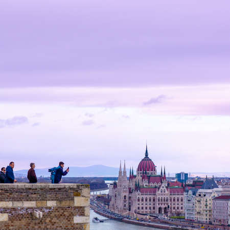 Budapest, Hungary 03 16 2019: Tourists take pictures of the city from the Buda Castle on a cloudy day. In the background is the Hungarian parliament. Image in shades of purple.のeditorial素材