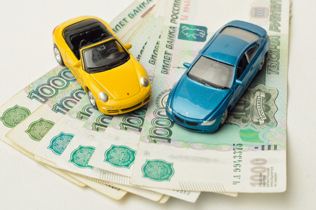 toy cars on Bank of Russia's paper banknotes, a white background. Russia, Volgograd region, 14 March 2017のeditorial素材