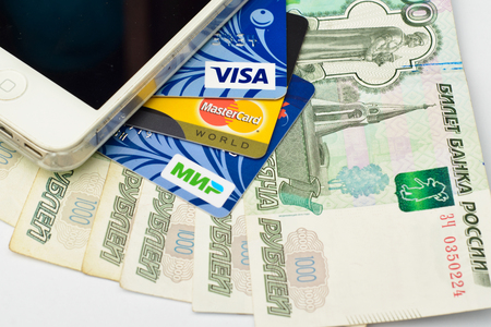 Plastic cards of VISA, Mastercard and MIR payment systems on paper banknotes. Russia, Volgograd region, 22 March 2017のeditorial素材