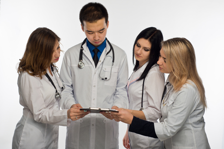 young doctors are reading documents attached to black clipboardの写真素材