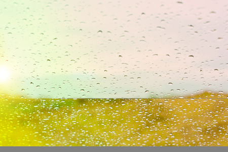 Water drops on glass against the sunset backgroundの写真素材