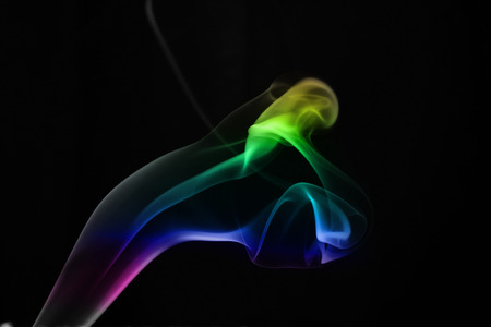 A whisp of colorful smoke against the white backgroundの写真素材