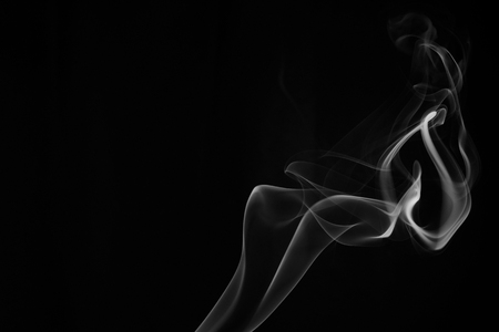 A whisp of white smoke against the black backgroundの写真素材