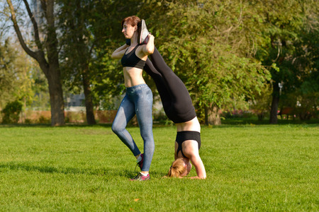 Two girls are helping each other to warm up muscles before exercisesの写真素材