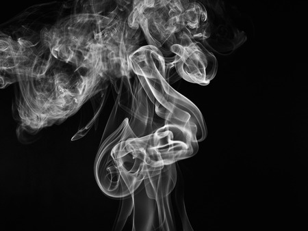 A whisp of white smoke against the black backgroundの写真素材