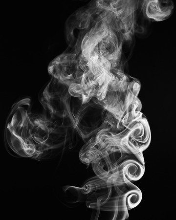 A whisp of white smoke against the black backgroundの写真素材
