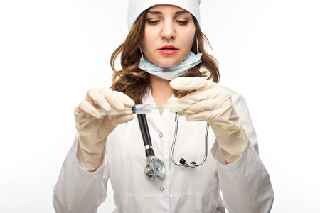 young intelligent woman doctor in white medical dressing gown is holding medical device in hands, looking at camera ( isolated on white background)の写真素材