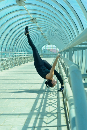 Girl doing stretching exercises in the tunnel pedestrian crossing.