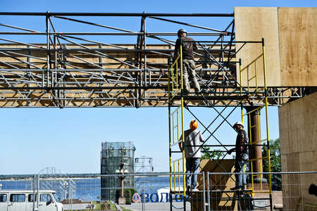 Pair of mounting work fixed plywood panels on top, working on specially constructed scaffolding.  Volgograd, Russia 27 may 2018のeditorial素材
