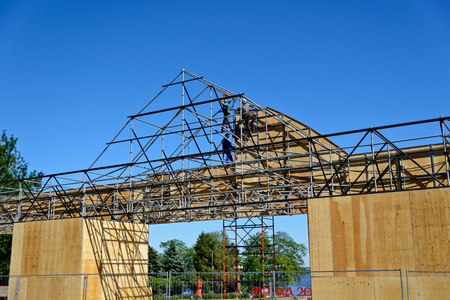 Pair of mounting work fixed plywood panels on top, working on specially constructed scaffolding.  Volgograd, Russia 27 may 2018のeditorial素材