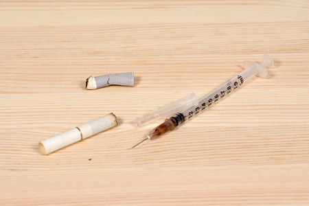 Used syringe and several cigarette butts as a sign of drug abuse and Smokingの写真素材