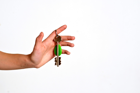 House key with trinket house in the female palm. Rental estate. Sale property template.の写真素材