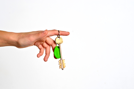 House key with trinket house in the female palm. Rental estate. Sale property template.の写真素材