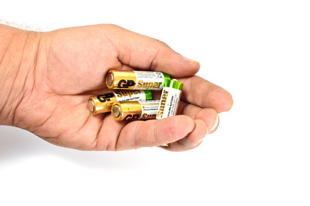 Several spent color alkaline batteries in the hand of a man on a white background. Recycling, energy, energy, environment and ecology concept-close your hands holding alkaline batteries pile. Russia, Volgograd, August 19, 2018のeditorial素材