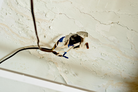 Exposed wires with wire-nuts, dangling from a hole in the ceiling. Code violation.の写真素材