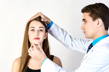 Medical examination face of beautiful woman by beautiful doctorの写真素材