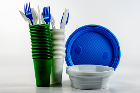The bright plastic disposable tableware on white background, the concept of conservation. Plastic recyclingの写真素材