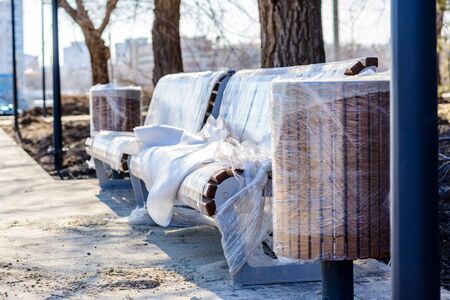 Street benches placed on newly laid tiles and packed in polyethyleneの写真素材