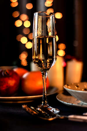Transparent liquid with carbon dioxide bubbles in a glass glass on the background of Christmas lightsの写真素材