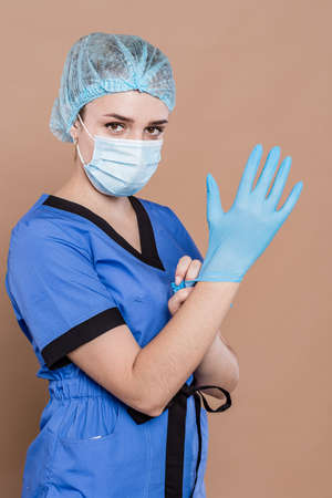 Woman in medical workwear with bottle and ampule with medicines in hands. Isolated on white background. Focus on hands.の写真素材