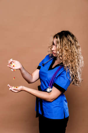 Woman in medical workwear with bottle and ampule with medicines in hands. Isolated on white background. Focus on hands.の写真素材