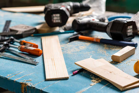 Set of assorted work tools and shavings on wooden blue background. Carpentry, concept.の写真素材