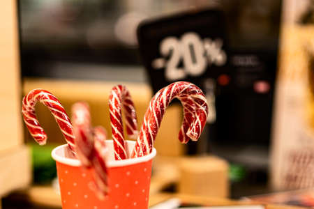 Red and white caramel sticks in a paper cup as one of the symbols of the Christmas holidays against...