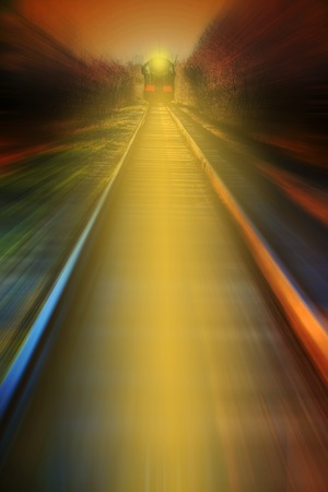 Nighttime shot of an electric train with light crossing .の写真素材