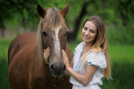 outdoor portrait of young beautiful woman with horse.の写真素材