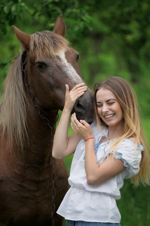 outdoor portrait of young beautiful woman with horse.の写真素材