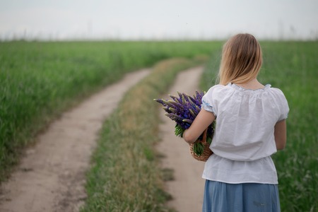 Portrait of beautiful young woman with flowers in the field.の写真素材