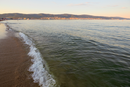 Still blue sea water under colorful evening cloudy sky.の写真素材