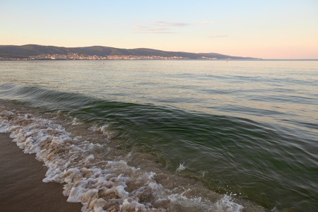 Still blue sea water under colorful evening cloudy sky.の写真素材